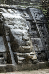 Fototapeta na wymiar One of the Olmec style stone faces on the Lamanai Mayan temple in the rain forest of Belize.
