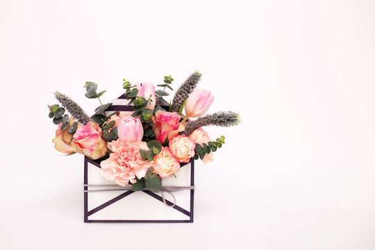 Opened envelope with flower arrangements on a white background. Festive greeting concept.
