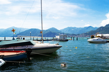 Fototapeta na wymiar Beautiful view of the coast of Italy. Beautiful view from the boats at the shore. Lake with boats along the coast of Italy.
