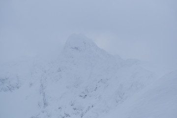 Fototapeta na wymiar piękna zaśnieżona góra we mgle