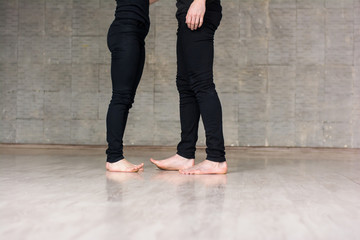 Two dancers on grey background. Young couple of dancers studying new dance over grey background, cropped image.