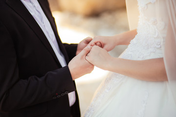 Bride and groom holding hands in wedding celemony