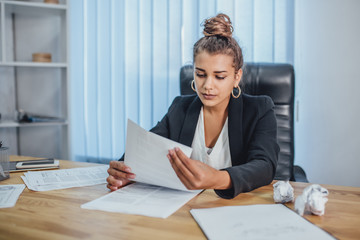 Young business girl in office working with documents. During this, they are browsing them. Hurling...