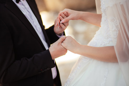 Bride and groom holding hands in wedding celemony