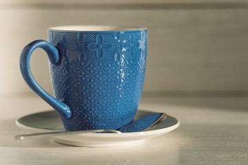 coffee in a blue cup on a light wooden background