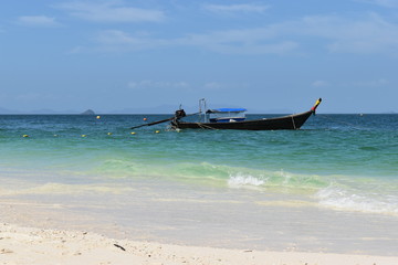 Beautiful lonely beach with a wooden long-tail boat in front at Poda Island in Krabi, Thailand, Asia