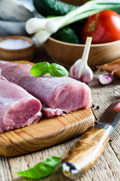 Fresh pork tenderloin, meat on wooden cutting board