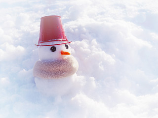 Little snowman with a bucket on the head and in a scarf on snow in sunny winter day