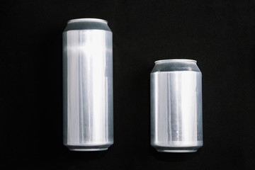 Big 0.5 and small 0.33 aluminium cans on black background.