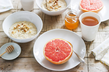 Vegetarian breakfast for two of oatmeal, baked grapefruit and tea. Rustic style.