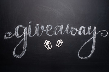 Inscription Giveaway written on the board with gifts