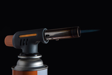 burning gas burner with propane on a black background close-up