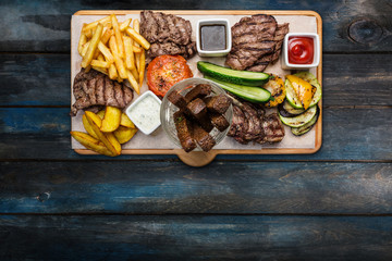 Beer snacks set. Meat set served on cutting board with the wooden background.