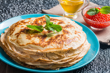 Stack of yeast pancakes, traditional for Russian pancake week witn red cavier and honey