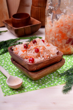 Sauerkraut with cranberry in a wooden bowl. Russian cuisine appetizer