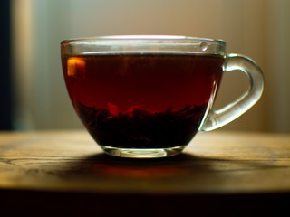 Transparent cup of golden strong tea. Glass cup with tea.