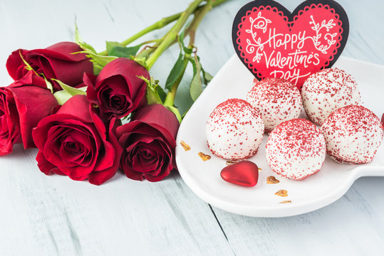 Gift for Valentines Day with plate of mini cakes and red roses.