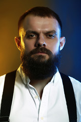 close up portrait , model, man, young handsome man with big beard on black yellow and blue background 