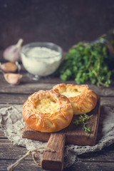 Fresh homemade open patties with cheese. Traditional Russian yeast pastry, round buns, curd tart. Buns with cottage cheese. Rustic style. Wooden background