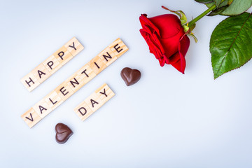 Happy Valentine day with red rose on white background with two chocolate hearts