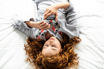 A redhead young teen girl on her bed
