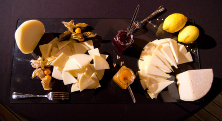 appetizer of cheeses served with mustard, jams and lemons