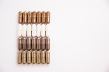 a lot of capsules of tablets lies on a white background
