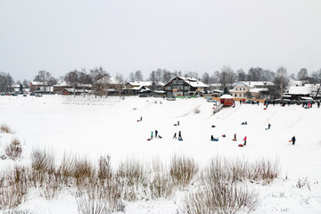 Provincial winter landscape. Holiday, ride from a hill. Veliky Ustyug, Russia.