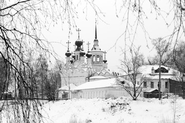 The Orthodox Church in the winter Veliky Ustyug framed by tree branches. Black and white photography