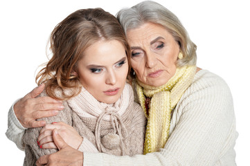 Sad senior woman with daughter on white background
