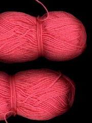 Skein of colored yarn on a dark background. A skein of pink yarn.