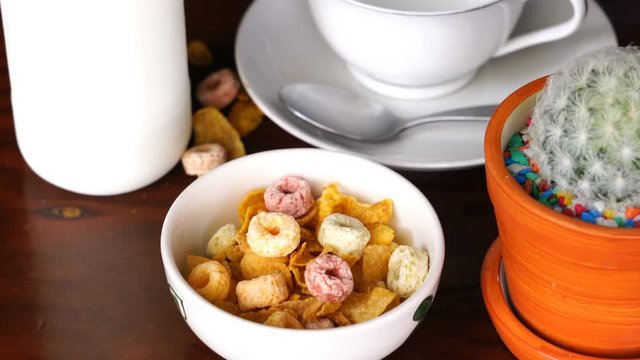 Pouring milk into a bowl of Corn Flakes and Froot  Loops for delicious breakfast