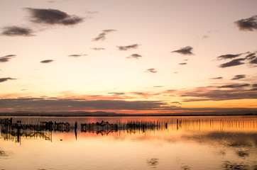 Fototapeta na wymiar Beautiful orange sunset on one day cloudy in the famous lake of the albufera of Valencia, Spain.