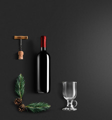Mulled wine recipe ingredients and kitchen accessories, bottle of red wine, cinnamon, anise stars, orange, brown sugarand spice on black background.