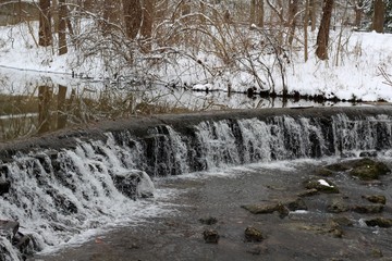 The cascading waterfall in the snowy landscape.