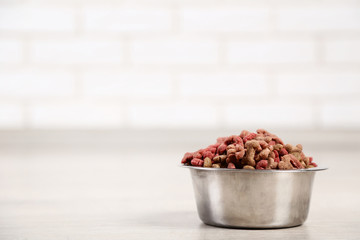 Dry pet food in bowl on the floor at home