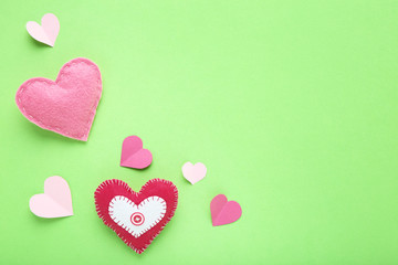 Fabric and paper hearts on green background