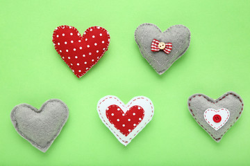 Colorful fabric hearts on green background