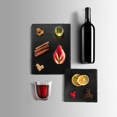 Mulled wine recipe ingredients and kitchen accessories, bottle of red wine, cinnamon, anise stars,...