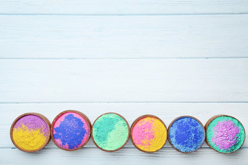 Colorful holi powder in bowls on wooden table