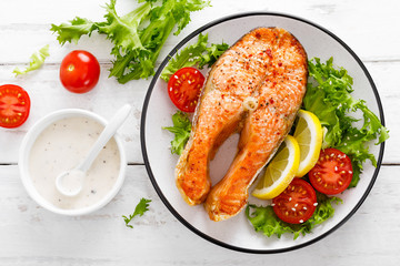 Salmon fish steak grilled and fresh vegetable salad with tomato and lettuce. Healthy food. Top view