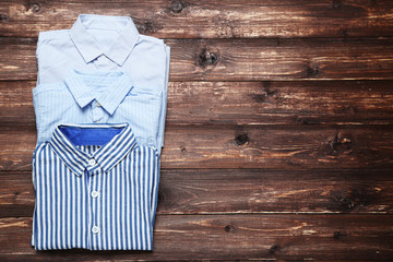 Folded shirts on brown wooden table