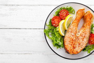 Salmon fish steak grilled and fresh vegetable salad with tomato and lettuce. Healthy food. Top view