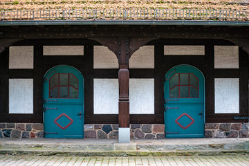 Fototapeta na wymiar altes Fachwerkhaus mit zwei türkis blauen Türen mit Rundbogen und Glaseinsätzen
