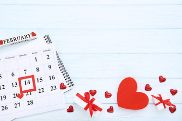 Valentine day calendar with red hearts and gift boxes on wooden table