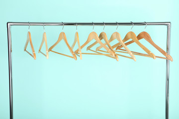 Wooden hangers hanging on mint background