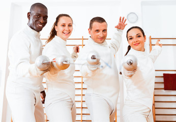 Men and women fencers practicing movements together at fencing workout