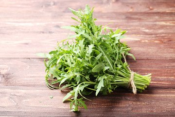 Green arugula leafs on brown wooden table