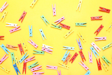 Colorful clothespins on yellow background
