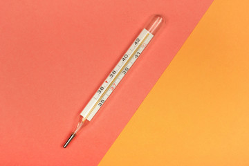 Medical mercury thermometer, Living Coral, trendy color 2019 background.  Free space for text.